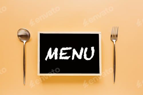Preview: Menu board with cutlery spoon fork orange paper background copy space place for text flat lay