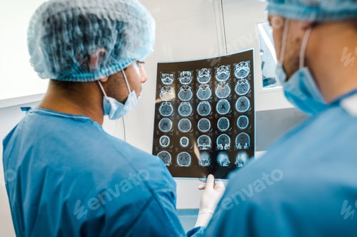 Preview: back view of doctors in uniforms and medical masks looking at x-ray