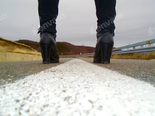 Preview: High heeled black boots in the middle of the road