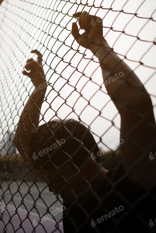 Preview: Hand with metal fence, feeling no freedom