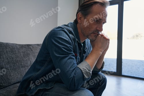 Preview: Sad mature male on couch at home
