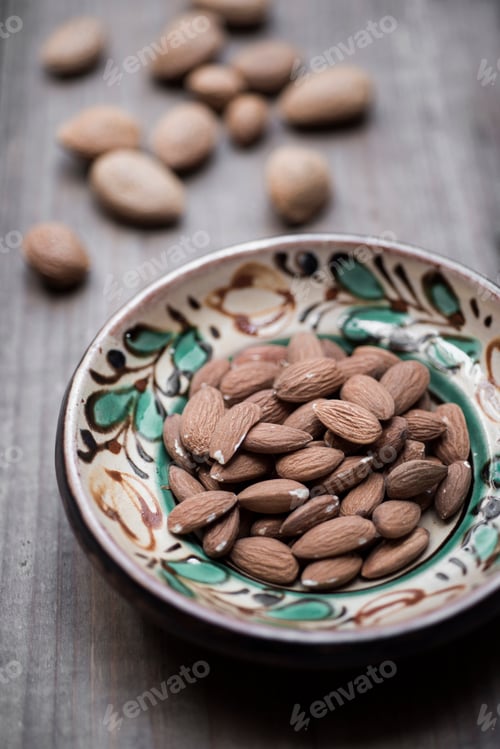 Preview: Almonds in hand-painted bowl on wood