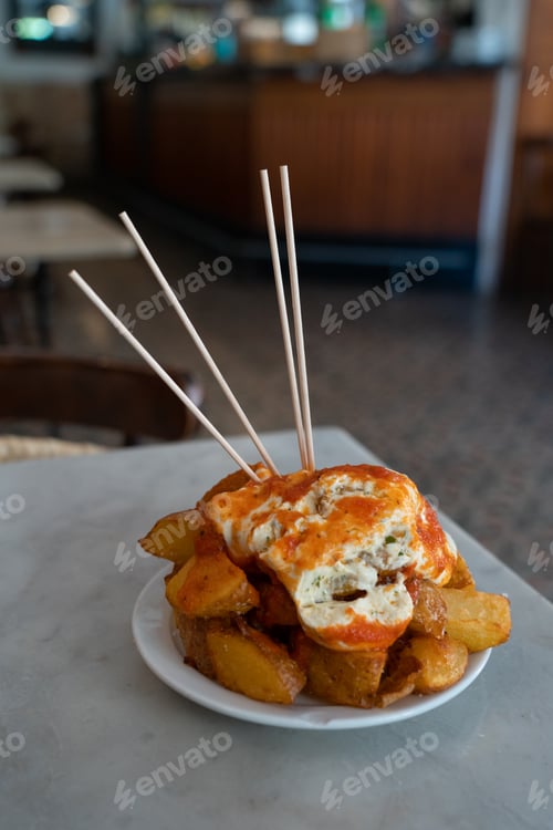 Preview: Patatas Bravas, traditional Spanish tapas, baked potatoes with spicy tomato sauce in a bar in Barcel