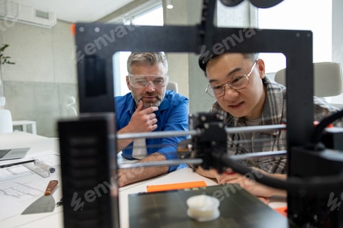 Preview: Colleagues engineers working with 3D printer process of printing.