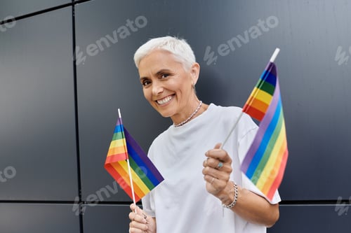 Preview: Stylish Lesbian Celebrating Pride With Rainbow Flags in Urban Setting During Daytime