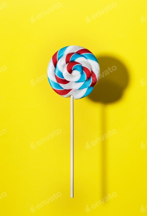 Preview: Swirl lollipop candy on a stick on yellow background, top view