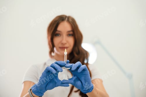 Preview: holding syringe for injection lips augmentation. Women's cosmetology in the beauty salon
