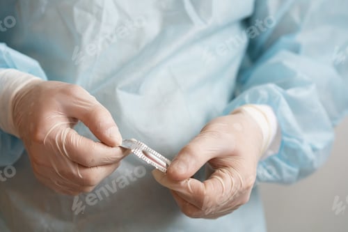 Preview: Doctor's hands in medical gloves with an anal candle, treatment of hemorrhoids, temperature control