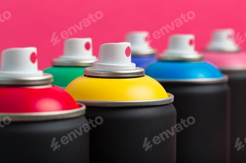 Preview: Bright spray paint cans lined up against a colorful background in an art studio setting