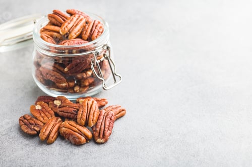 Preview: Peeled pecan nuts in jar on kitchen table.