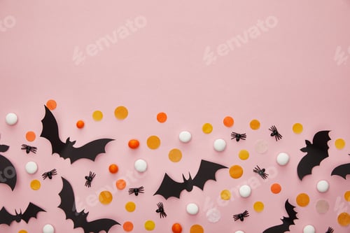 Preview: top view of bats and spiders with confetti on pink background, Halloween decoration