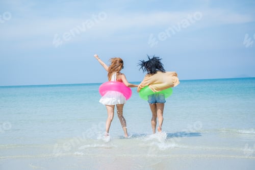Preview: Two attractive girls jumping on the beach, Having Fun, Summer Lifestyle.