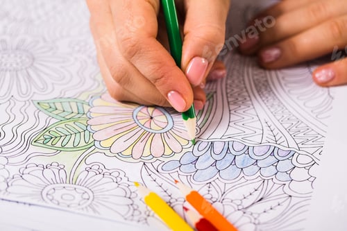 Preview: Girl paints a coloring book for adults with crayons