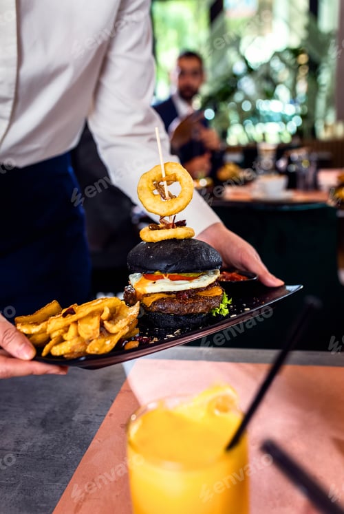 Preview: Close up of waitress hand serving meal in restaurant.