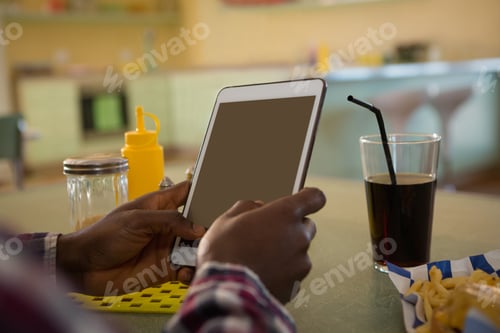 Preview: Man using digital tablet in restaurant