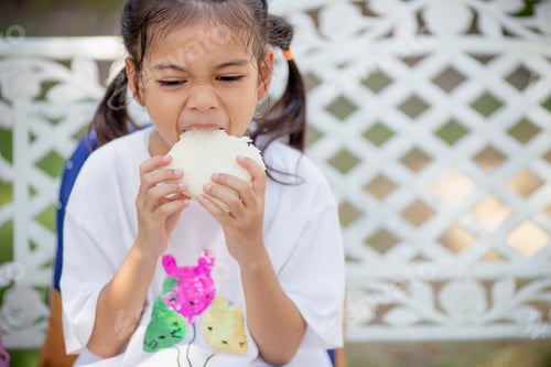 Preview: Cute schoolgirl eating outdoors the school. Healthy school breakfast for children. Food for lunch.