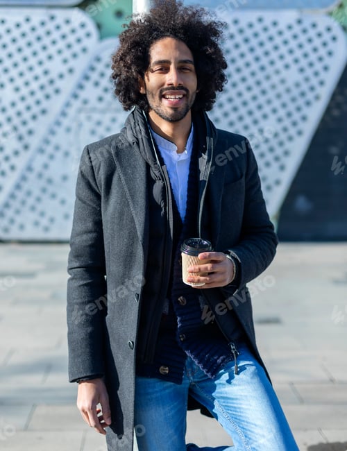 Preview: african american man with beard smiling standing at the street drinking a take away cup of coffee