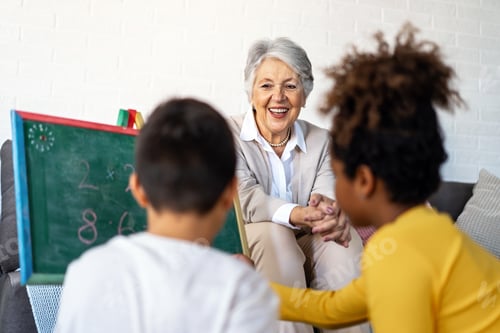 Preview: Happy grandmother, nanny helping to mixed race grandchildren with study. Homeschooling concept