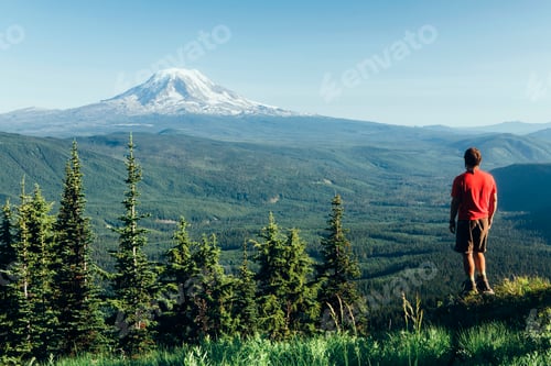 Preview: Male hiker on a mountain summit, looking at the landscape towards Mount Hood