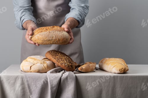 Preview: Baker holding freshly baked bread over table
