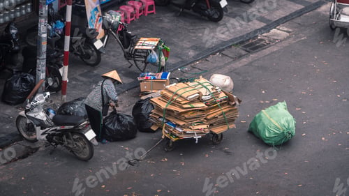 Preview: Aerial view of a Vietnamese woman collects cardboard and trash for recycling