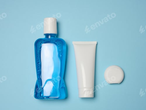 Preview: Mouthwash, toothpaste tube, dental floss on a blue background, oral hygiene