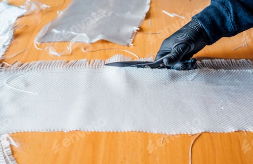 Preview: 62 year old man cutting fiber with scissors in the workshop.