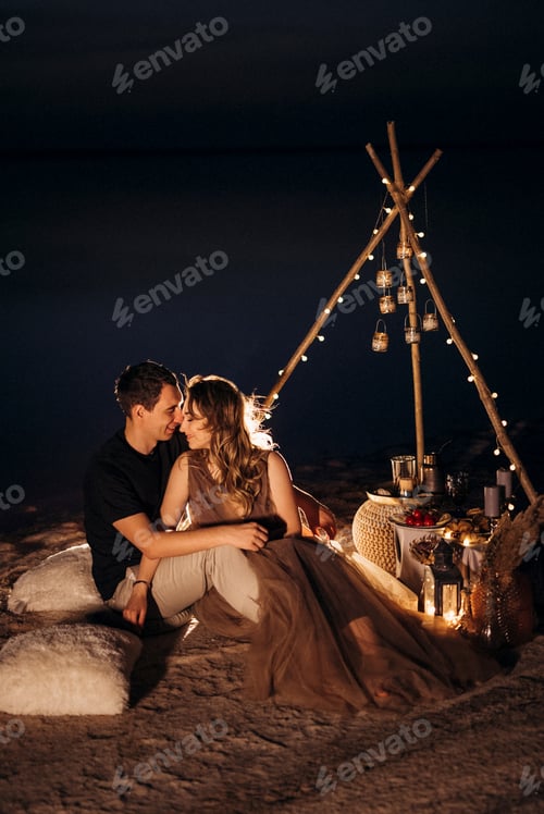 Preview: young couple having a picnic on the beach