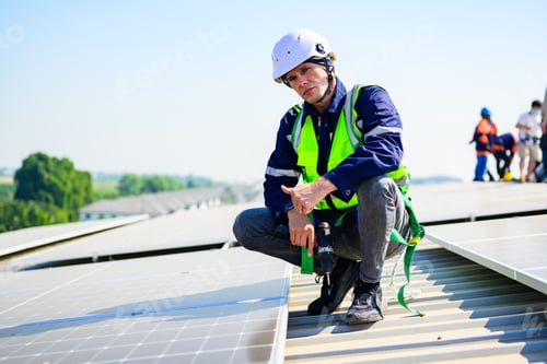 Preview: Professional engineer with safety helmet checking system at solar cell farm