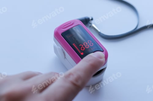 Preview: Finger presses a button on the pink pulse oximeter