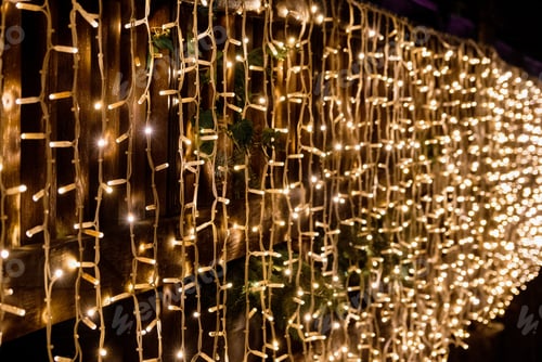 Preview: Christmas lights on strings hanging on railing of bridge.