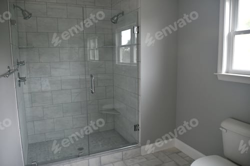 Preview: Shower with two shower heads and glass doors, gray tiles for sleek modern look.