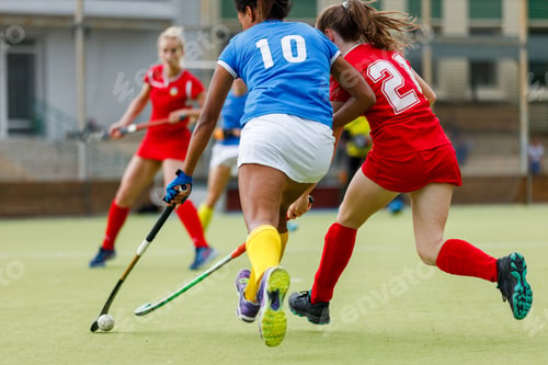 Preview: Female players compete for the ball during an attack in a field hockey match