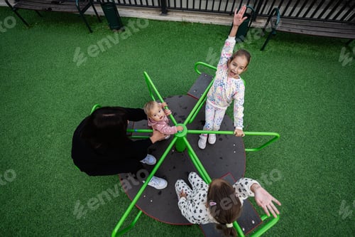 Preview: Children enjoying a fun day at the playground carousel