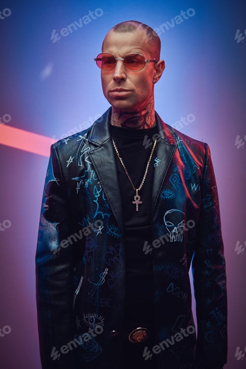 Preview: Rock styled serious guy posing in colored abstract background