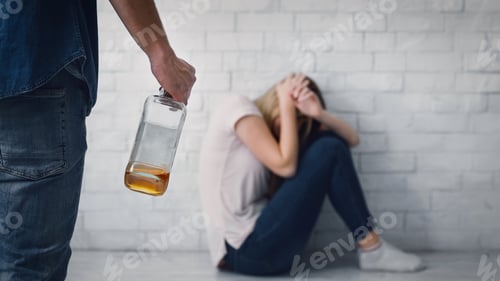Preview: Help for victim of aggressive alcoholic. Wife closes herself from blows of husband, with bottle in