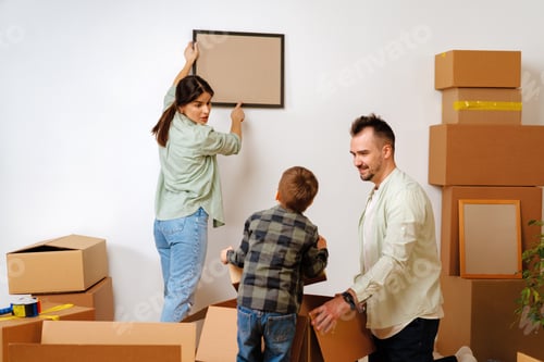 Preview: Young parents and son having fun during moving day to new house