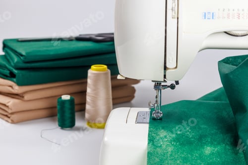 Preview: Sewing machine in action with fabric and threads on work table for crafting projects
