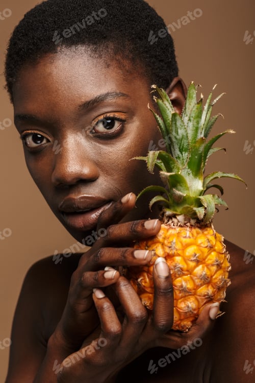 Preview: Beauty portrait of young half-naked african woman holding pineapple