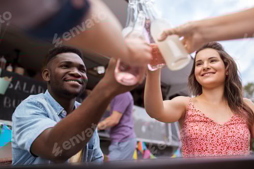 Preview: friends clinking bottles with drinks at food truck