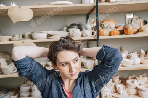 Visualização: Linda jovem ceramista recolhe o cabelo antes de começar a trabalhar