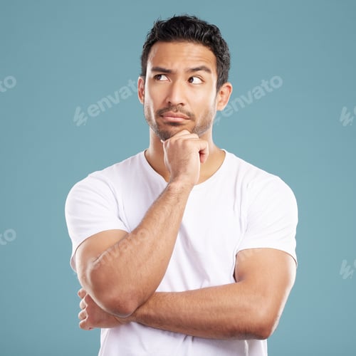 Preview: Handsome young mixed race man looking thoughtful with his hand on his chin and looking away while s