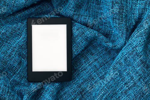 Preview: Electronic book with blank screen on blue knitted blanket