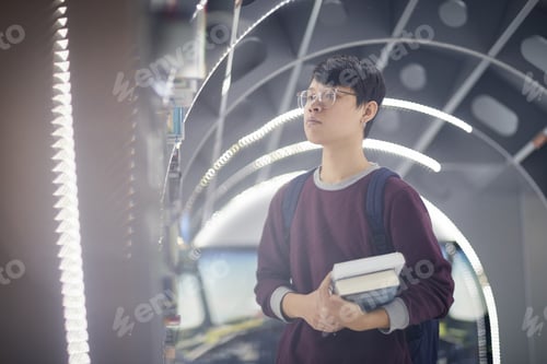 Preview: Asian student working in the library