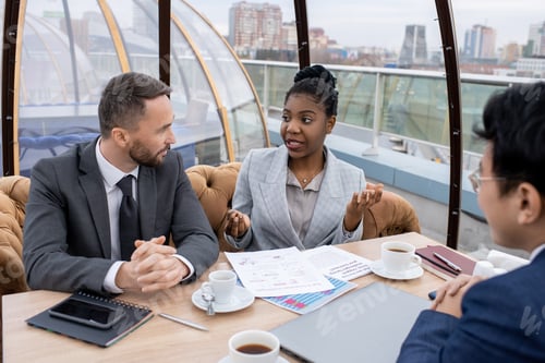 Preview: Young confident African businesswoman explaining financial data to colleagues