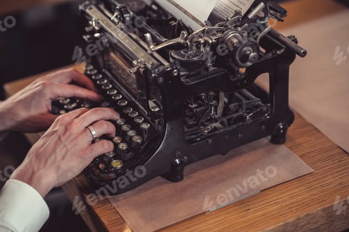 Preview: Men's hands typing on a retro typewriter