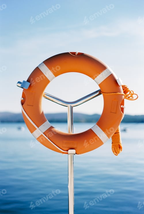 Preview: Red lifebuoy on a metal rack on the pier. Close-up