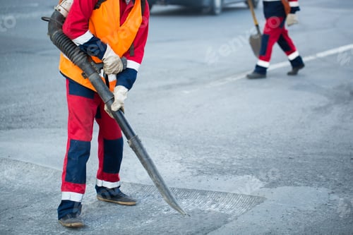 Preview: Worker with leaf-blower, cleaning out the dust for better asphalt adhesion, during tram track