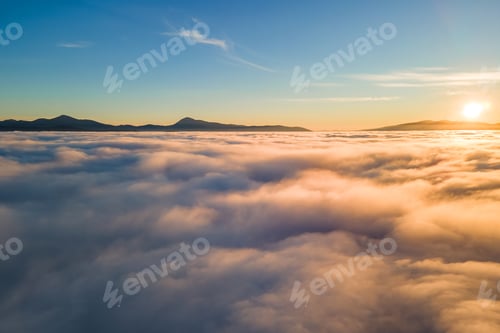 Preview: Aerial view of vibrant sunset over white dense clouds