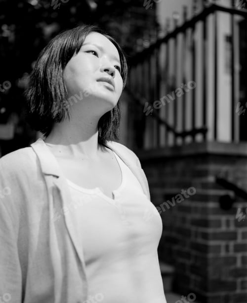 Preview: Young woman looking up in contemplation in monochrome